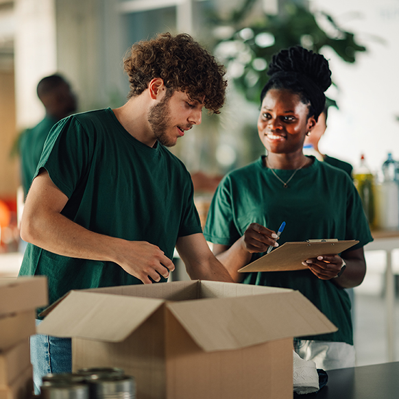 Young man and woman volunteers packing boxes 