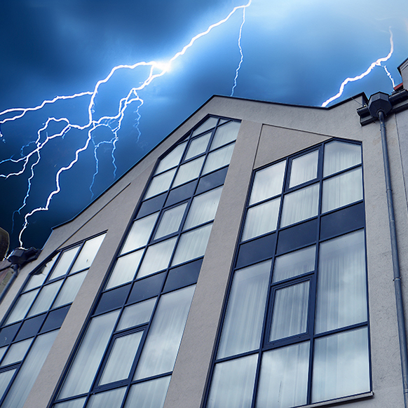 Lightning striking a community building with a dark blue evening sky above