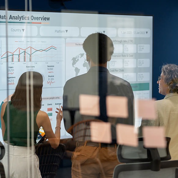 Financial team members analyzing projected data on screen on wall