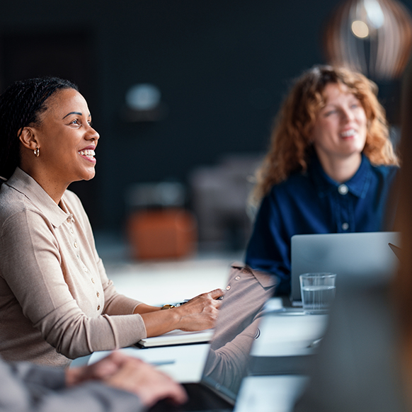 Two female actuarial professionals sitting in meeting discussing insurance