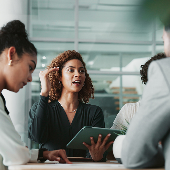 Professional woman discussing details with colleagues around a table in an office environment