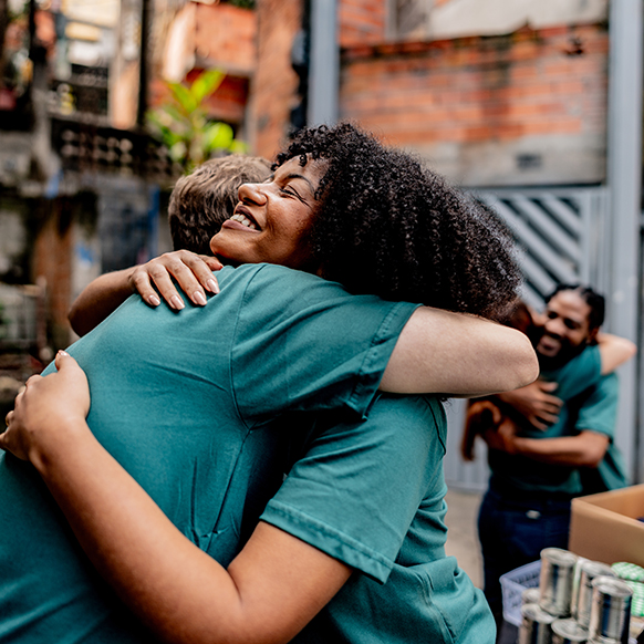 Volunteers hugging after a successful day helping others
