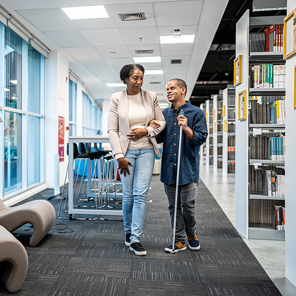 African women assisting a blind young man in library for special needs program