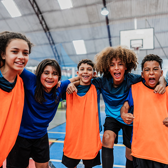 Youth group huddled together on a basketball court having a great time