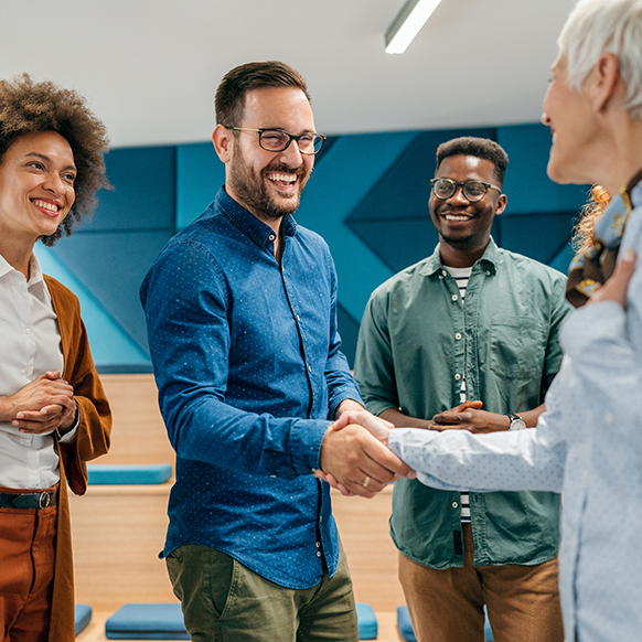 Group of specialists shaking hands with client and smiling