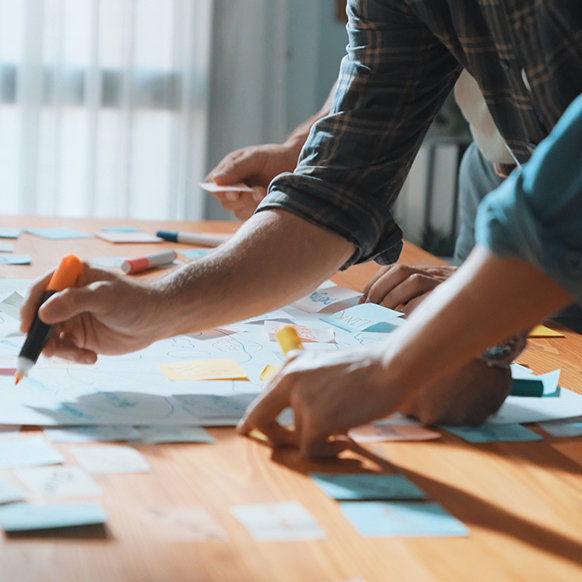 Close up of a professional team's work laid out on table strategizing the right path.