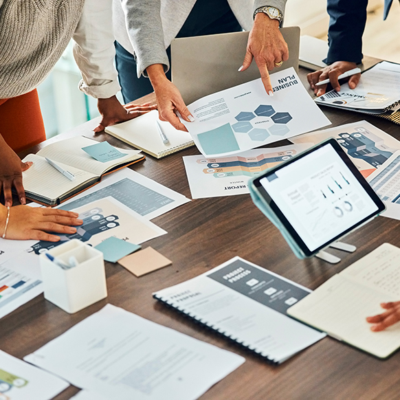 Insurance team around conference table with laptops and work planning strategy