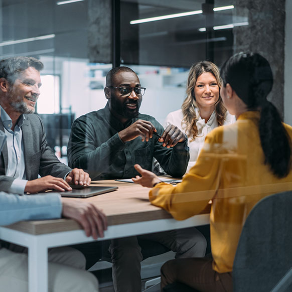 Specialized insurance team around conference table collaborating